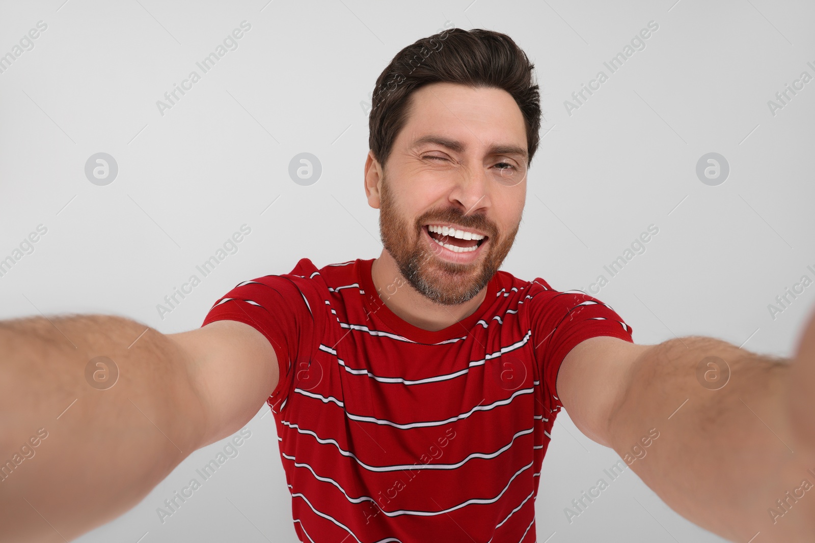 Photo of Smiling man taking selfie on white background