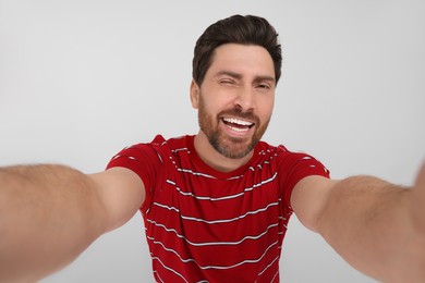 Smiling man taking selfie on white background
