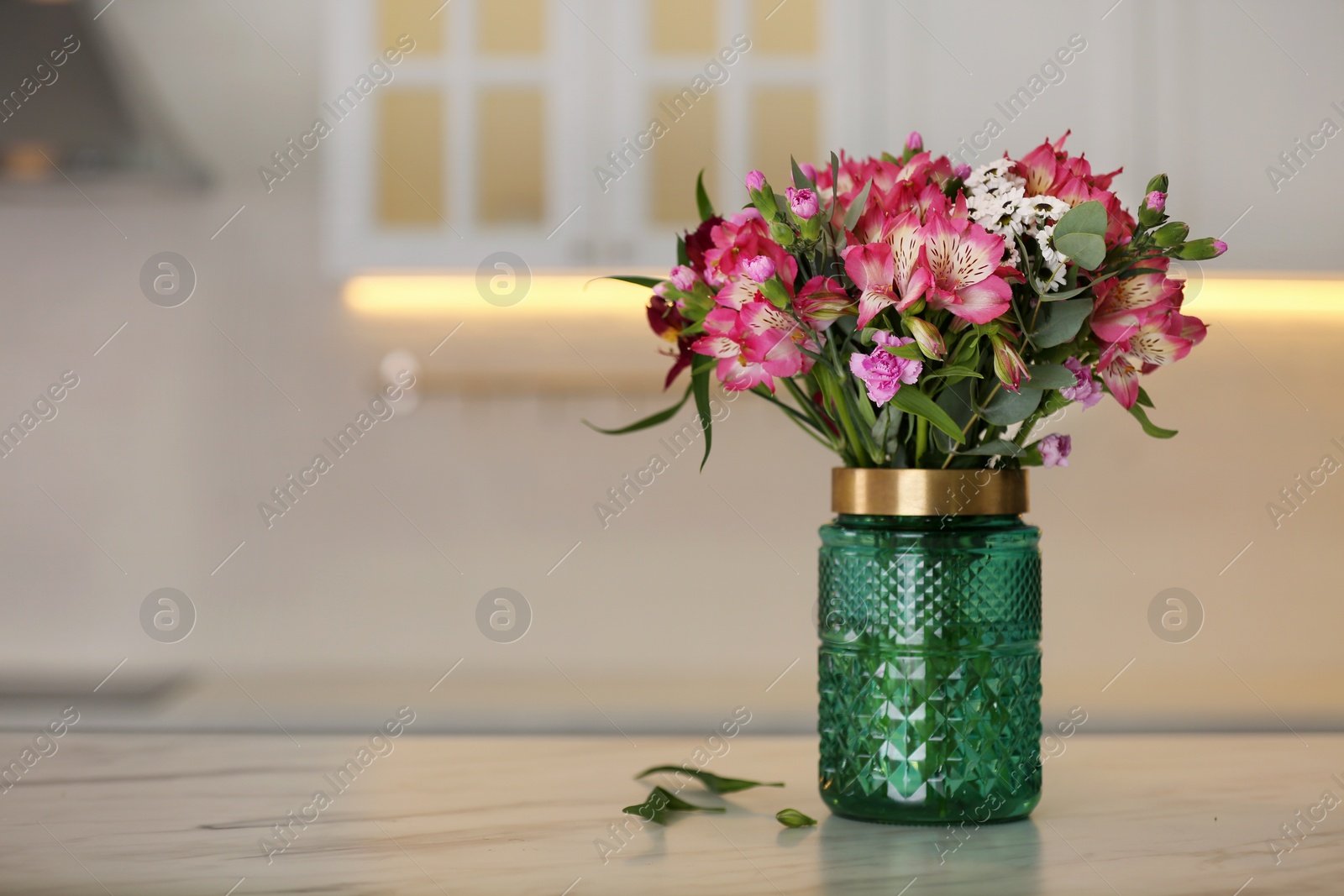Photo of Vase with beautiful alstroemeria flowers on table in kitchen, space for text. Interior design