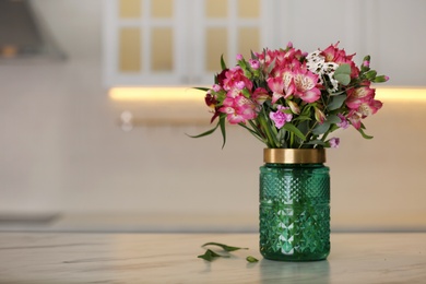 Vase with beautiful alstroemeria flowers on table in kitchen, space for text. Interior design