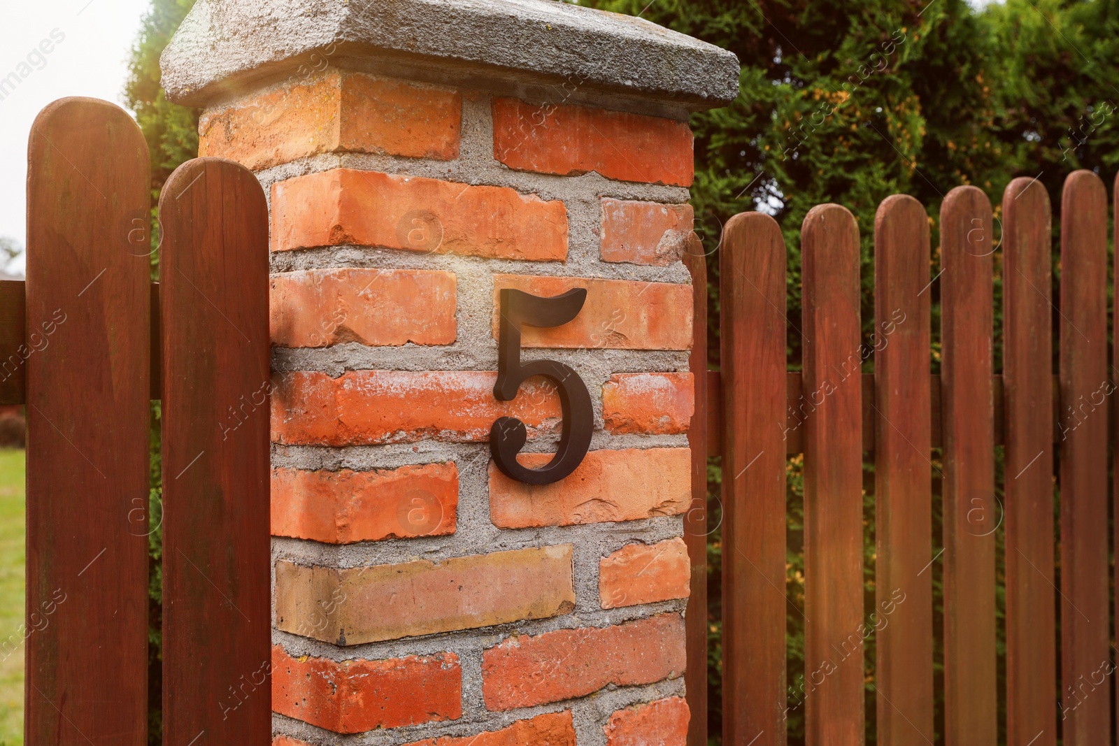 Photo of House number 5 on red brick column outdoors