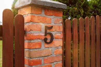House number 5 on red brick column outdoors