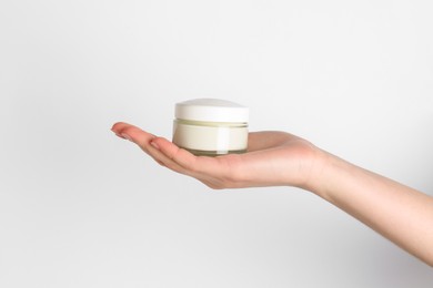 Woman with jar of cream on white background, closeup