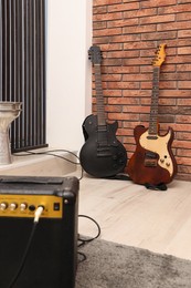 Photo of Modern electric guitars and amplifier in studio