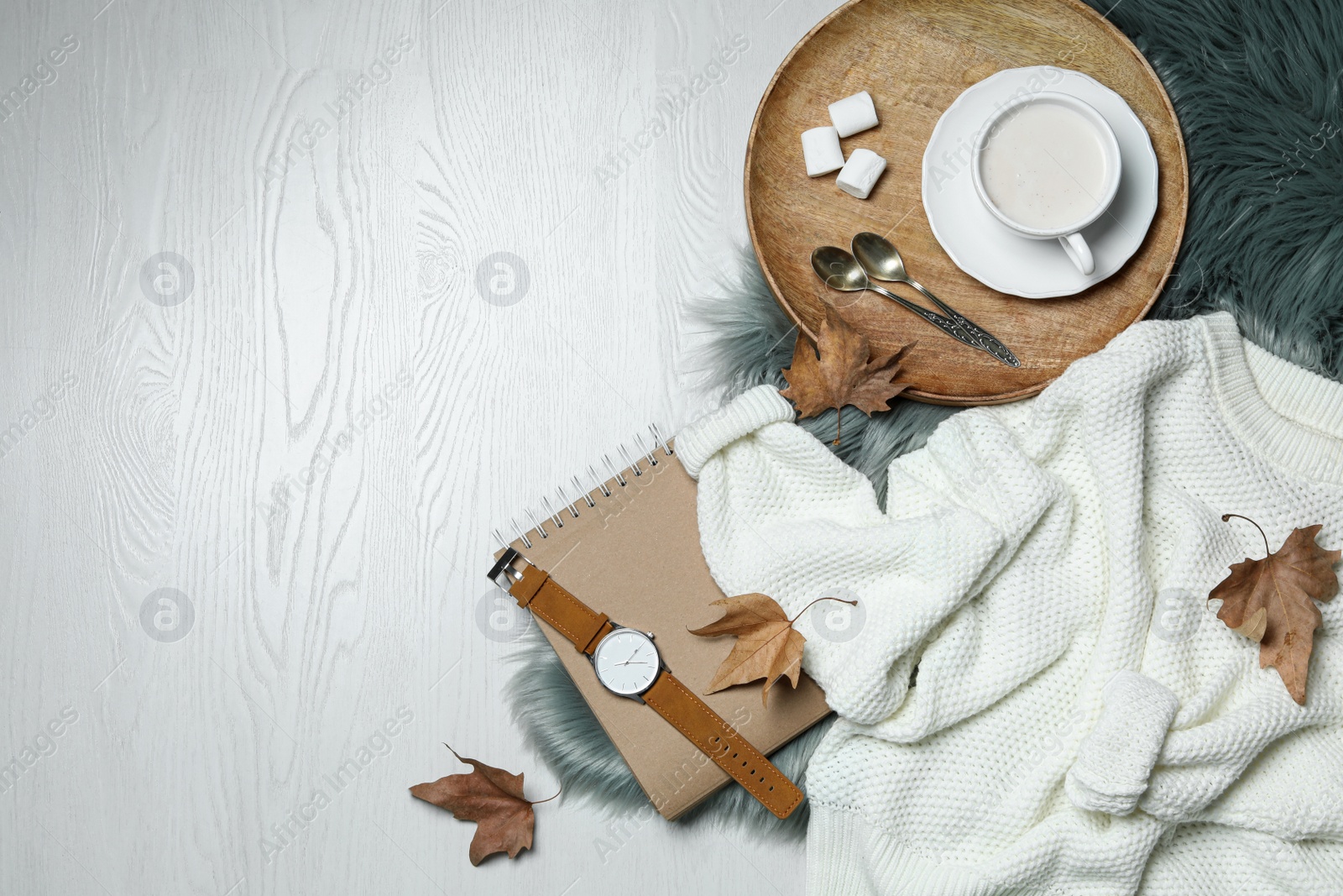 Photo of Flat lay composition with soft knitted sweater on white wooden background. Space for text