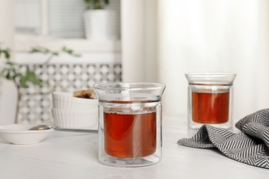 Photo of Glasses of hot fresh tea on table indoors