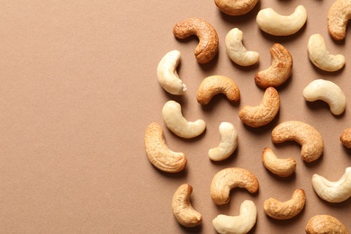 Photo of Tasty cashew nuts on color background, flat lay. Space for text