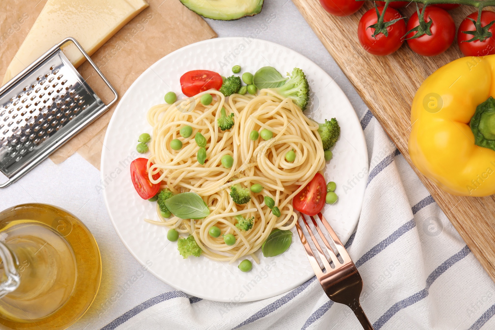 Photo of Plate of delicious pasta primavera, ingredients and fork on table, flat lay