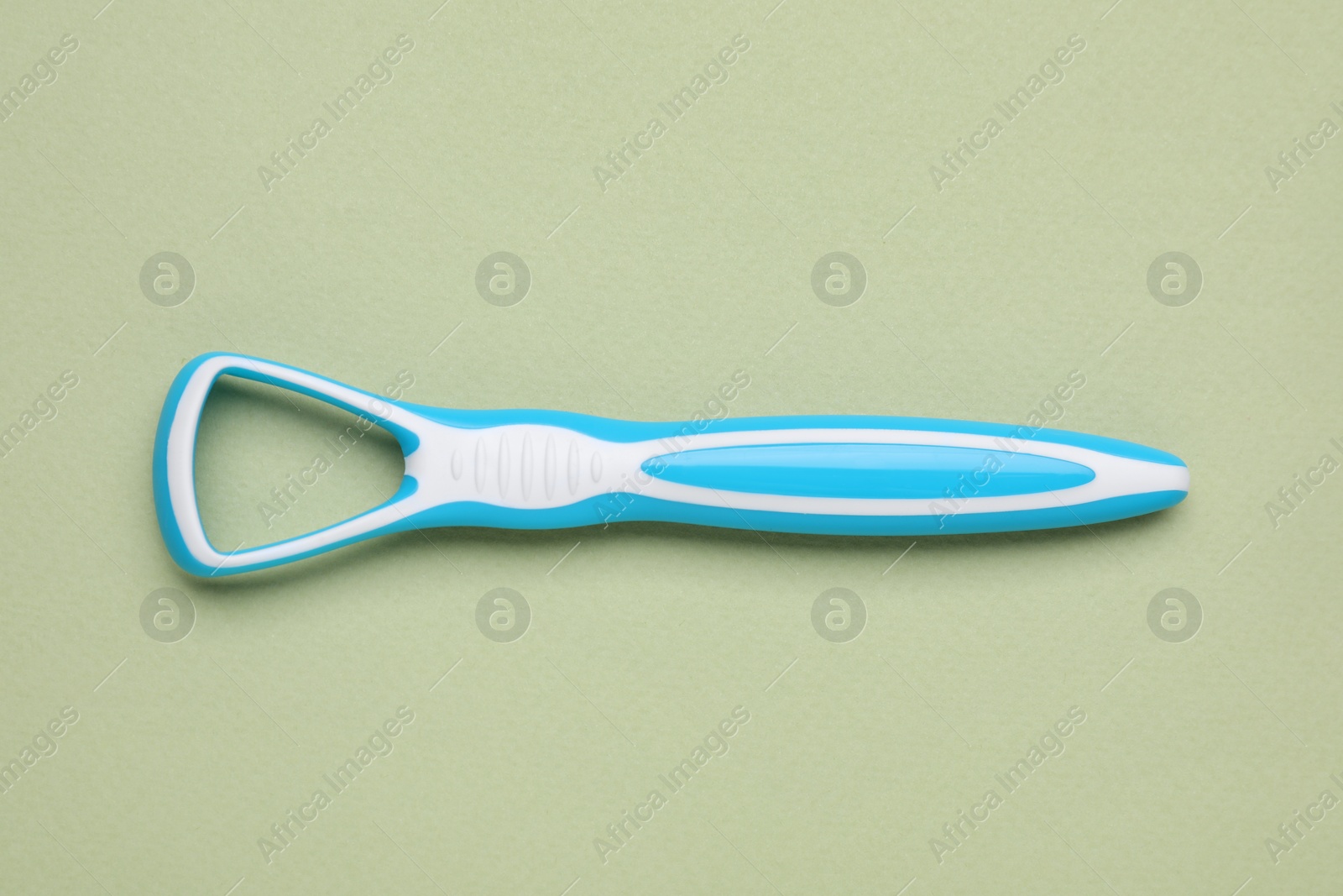 Photo of Light blue tongue cleaner on olive background, top view