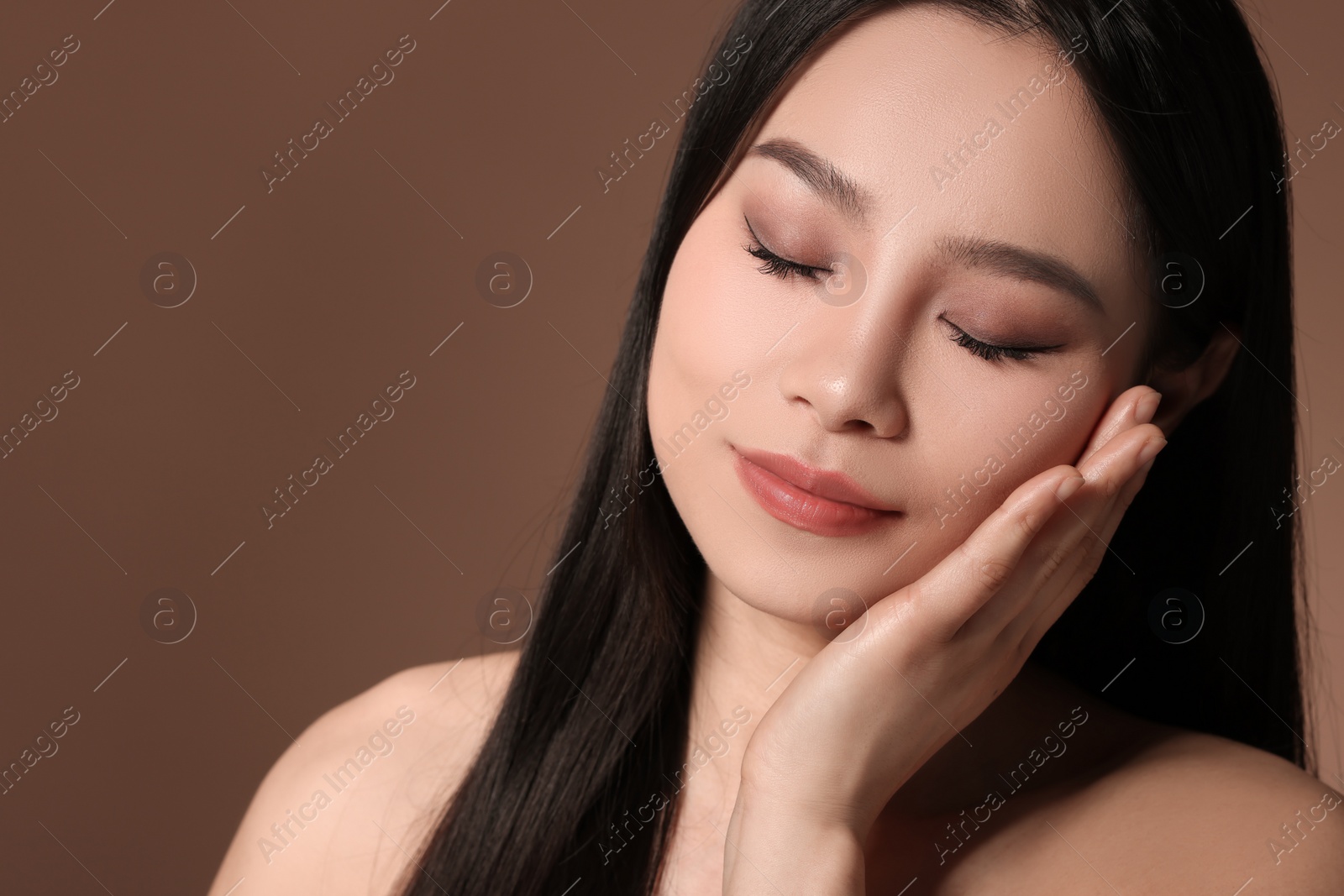 Photo of Portrait of beautiful woman on brown background