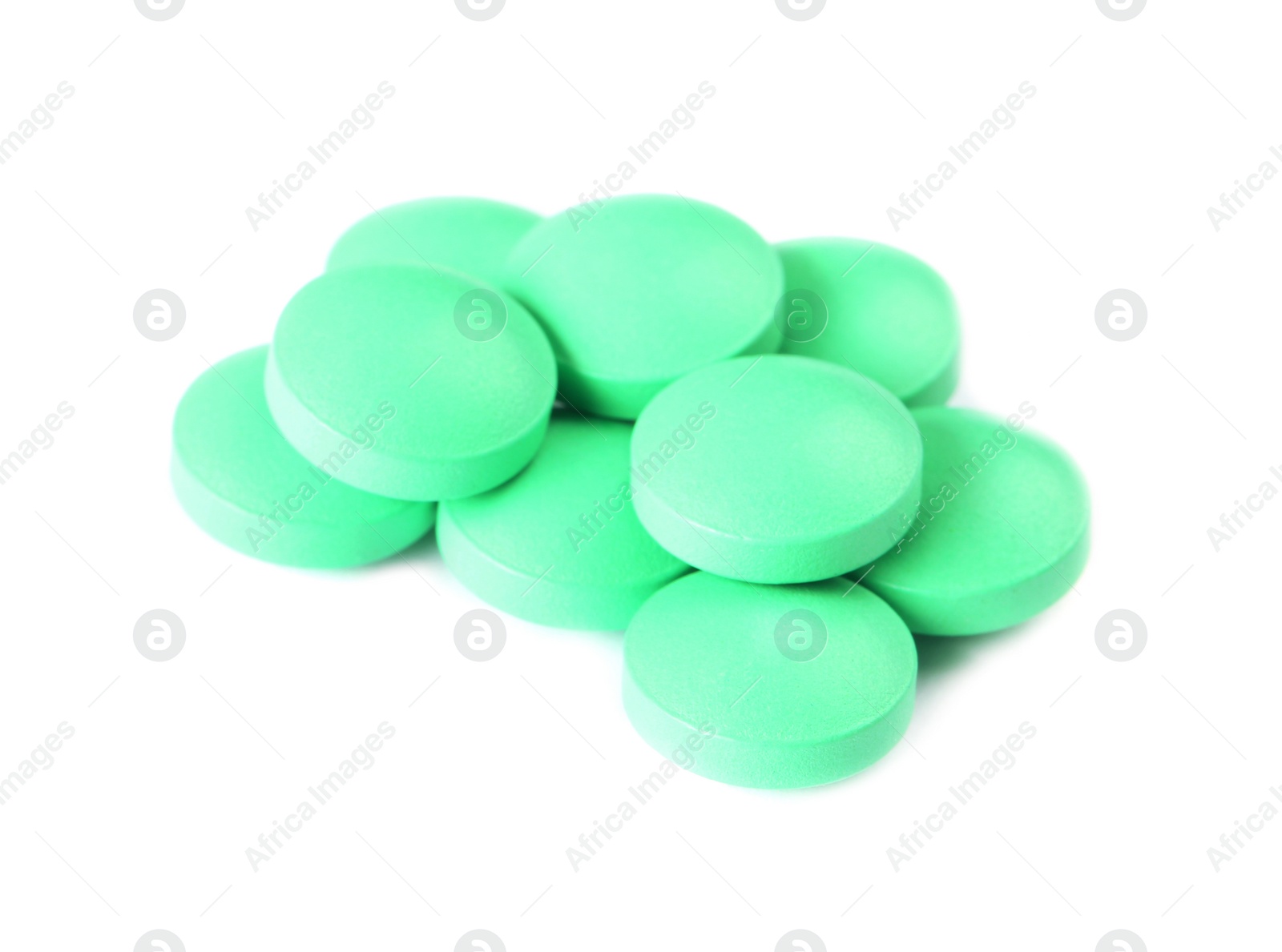 Photo of Pile of green pills on white background