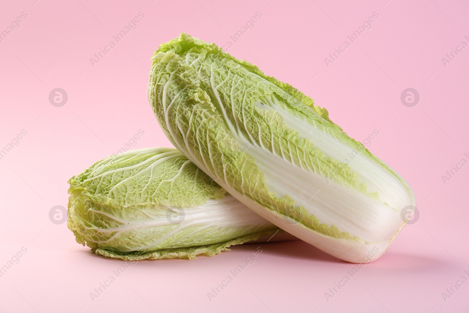 Photo of Fresh ripe Chinese cabbages on pink background