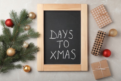 Flat lay composition with words DAYS TO XMAS, gifts and decorated fir branch on grey background. Christmas countdown