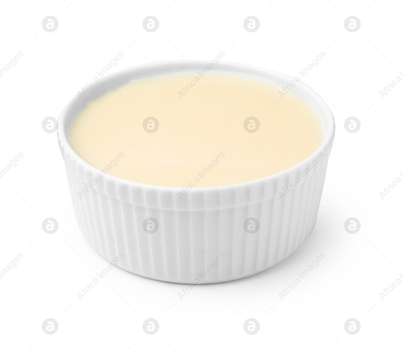 Photo of Bowl with condensed milk isolated on white