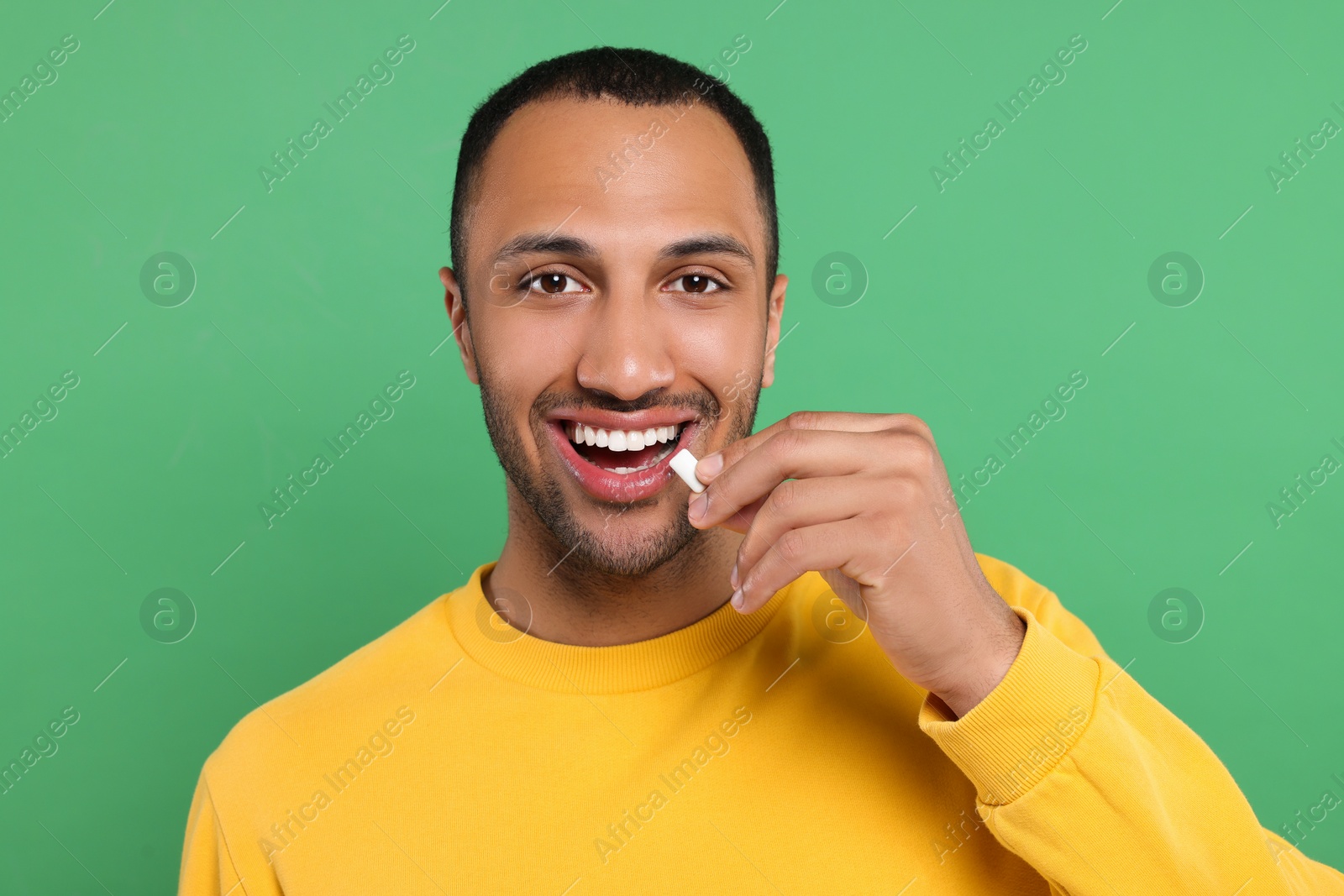 Photo of Portrait of happy man with bubble gum on green background