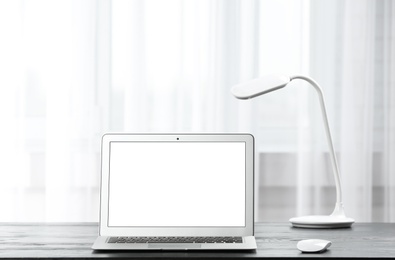 Photo of Laptop on desk in home office. Comfortable workplace