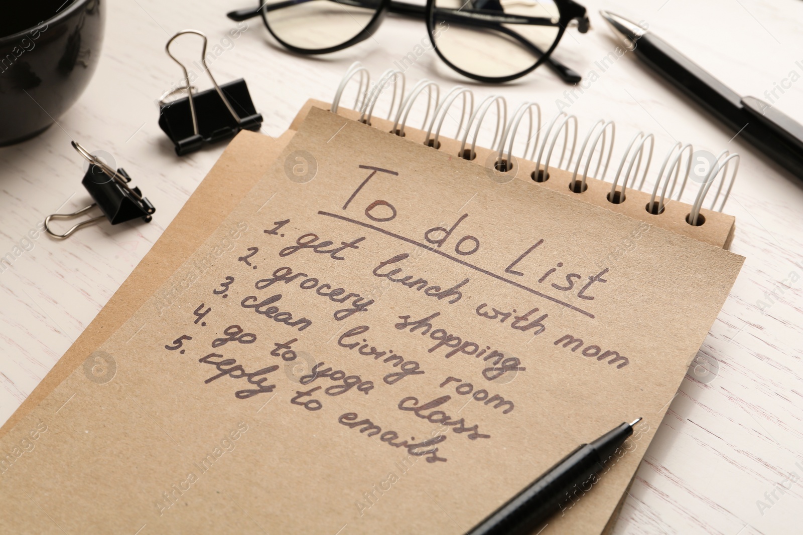 Photo of Notebook with to do list on wooden table