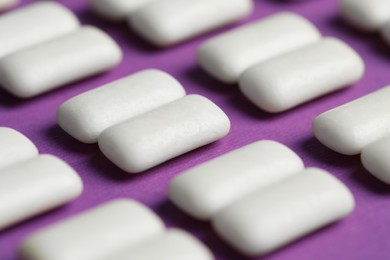 Photo of Tasty white bubble gums on purple background, closeup