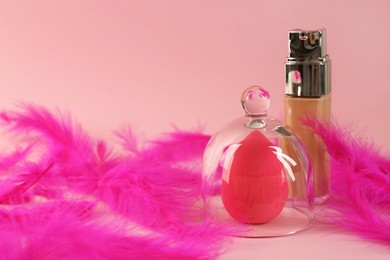Photo of Stylish presentation of makeup sponge and skin foundation on pink background