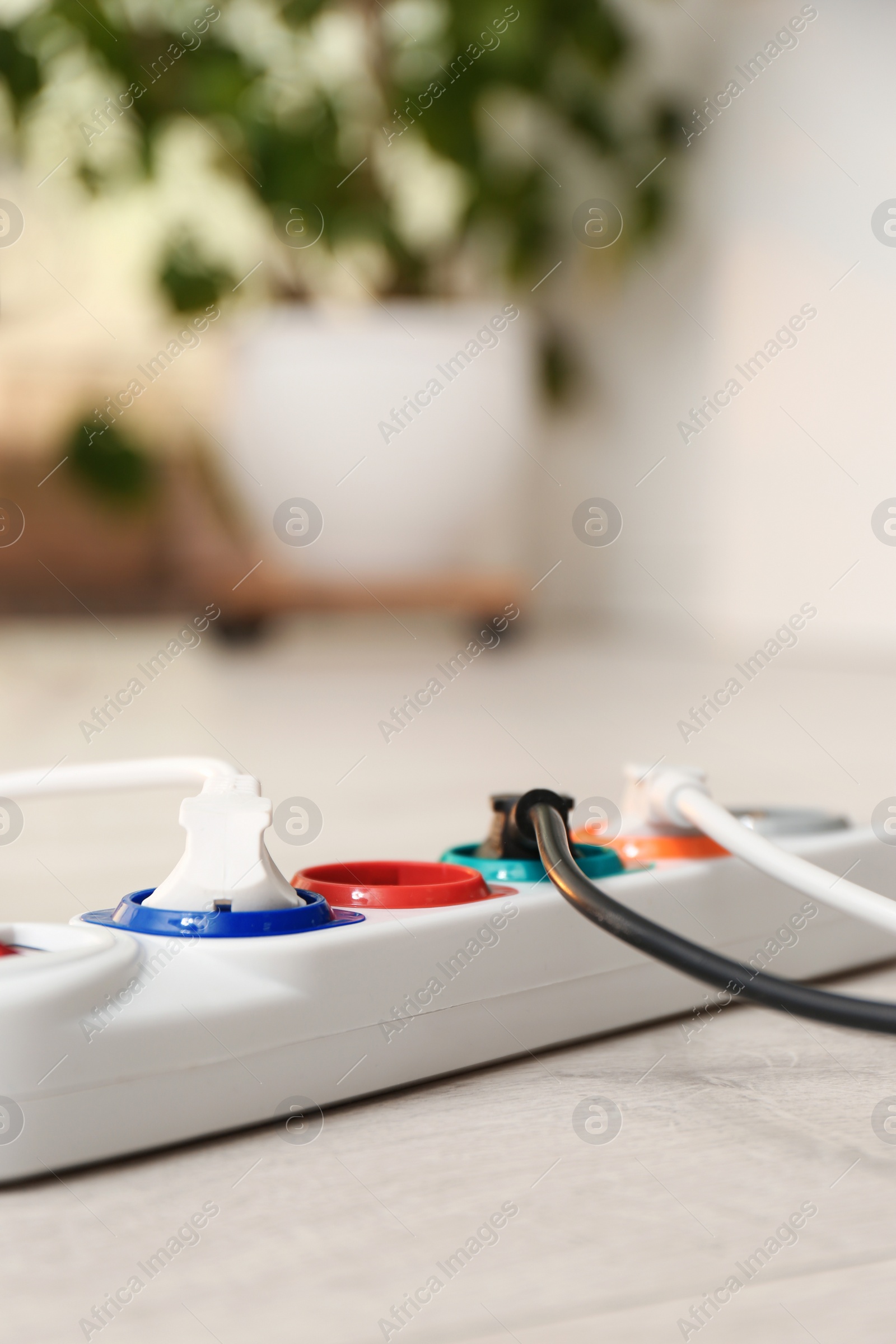 Photo of Extension cord on floor indoors, space for text. Electrician's professional equipment