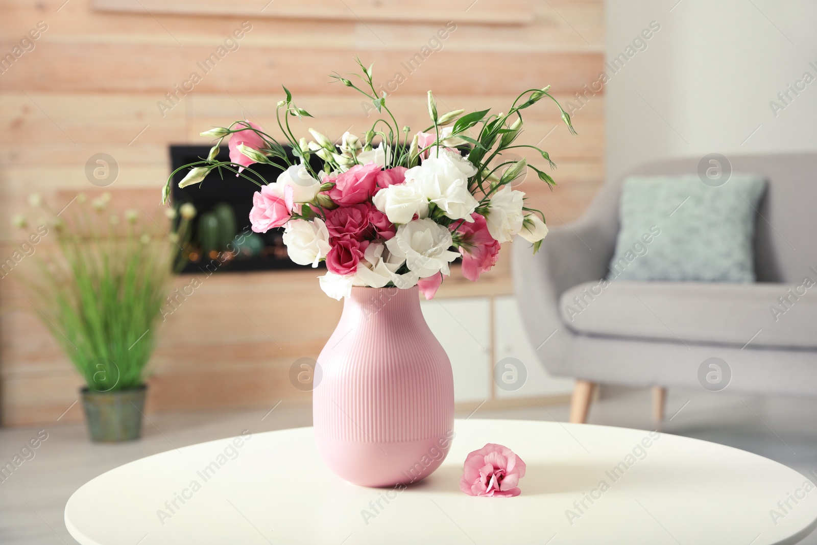 Photo of Vase with beautiful flowers on table in living room, space for text