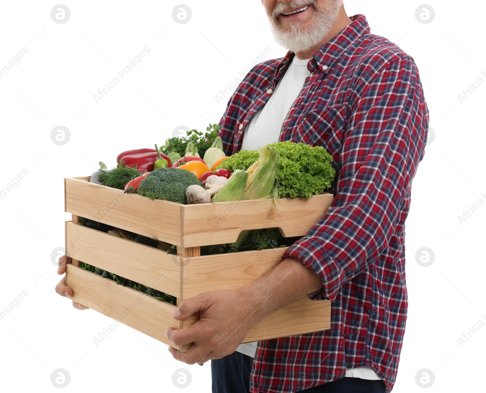 Photo of Harvesting season. Happy farmer holding wooden crate with vegetables on white background, closeup