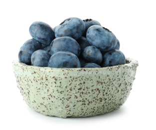 Bowl full of fresh ripe blueberries on white background