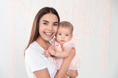 Portrait of happy mother with her baby against blurred lights. Space for text