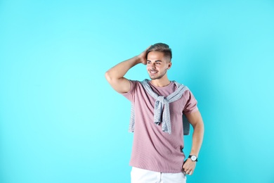 Photo of Young man with trendy hairstyle on color background