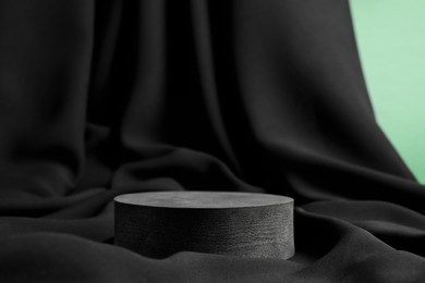 Photo of Round stand on black fabric, space for text. Stylish presentation for product