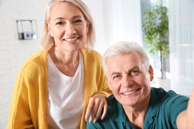 Mature couple using video chat at home, view from web camera