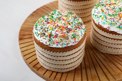 Photo of Traditional Easter cakes with sprinkles on white wooden table, closeup