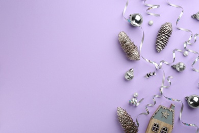 Photo of Flat lay composition with serpentine streamers and Christmas decor on violet background. Space for text