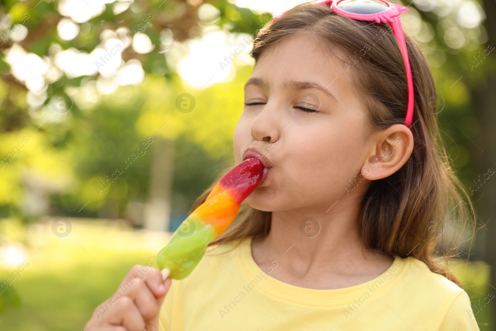 Photo of Cute little girl with delicious ice cream in park