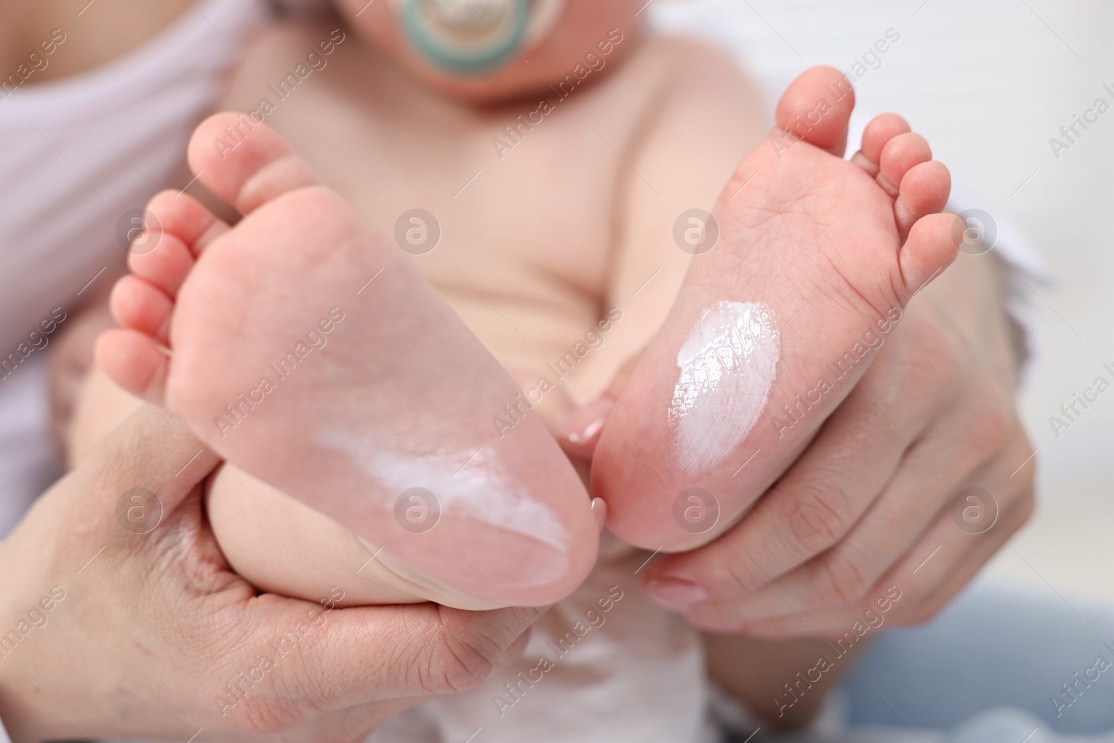 Photo of Mother holding baby`s feet on bed, closeup