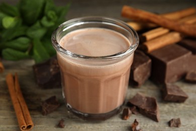 Photo of Glass of delicious hot cocoa on wooden table