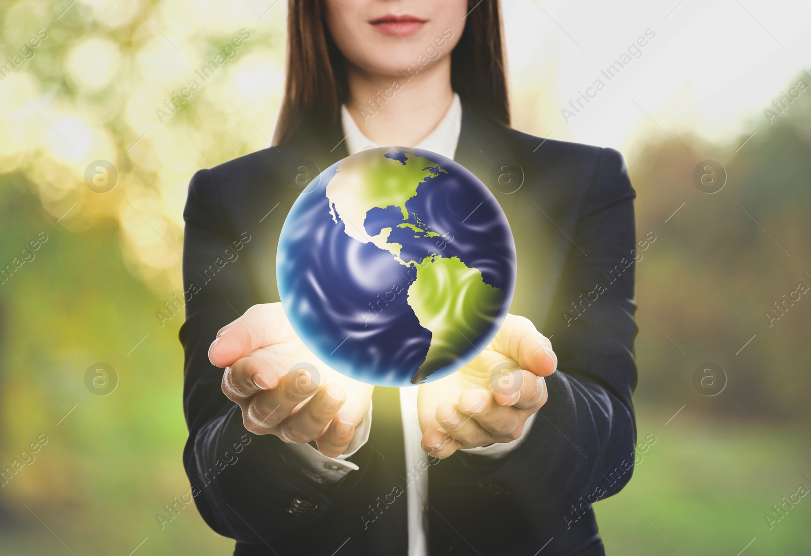 Image of Young woman holding Earth outdoors, closeup view