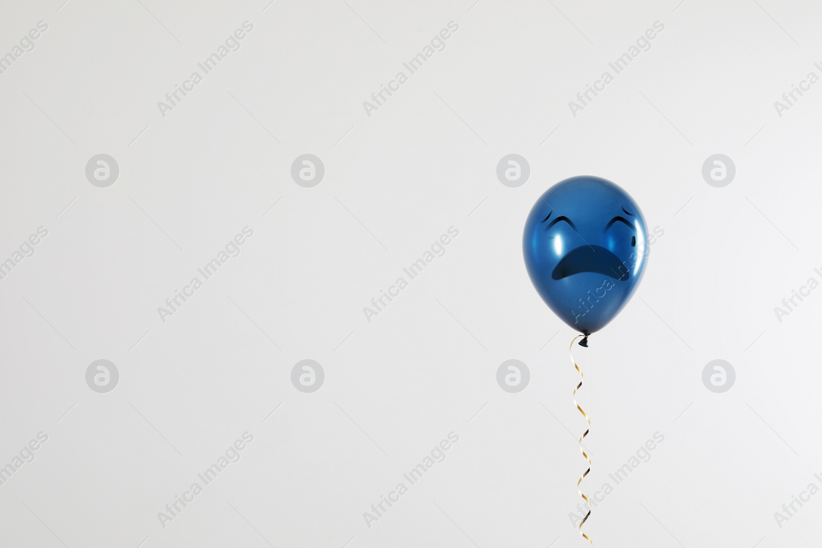 Image of Blue balloon with sad face on light grey background. Space for text