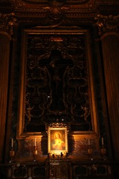 Rome, Italy - February 3, 2024: Ornate cross design of cruxification of Christ above altar. Church of St. Ignatius of Loyola at Campus Martius