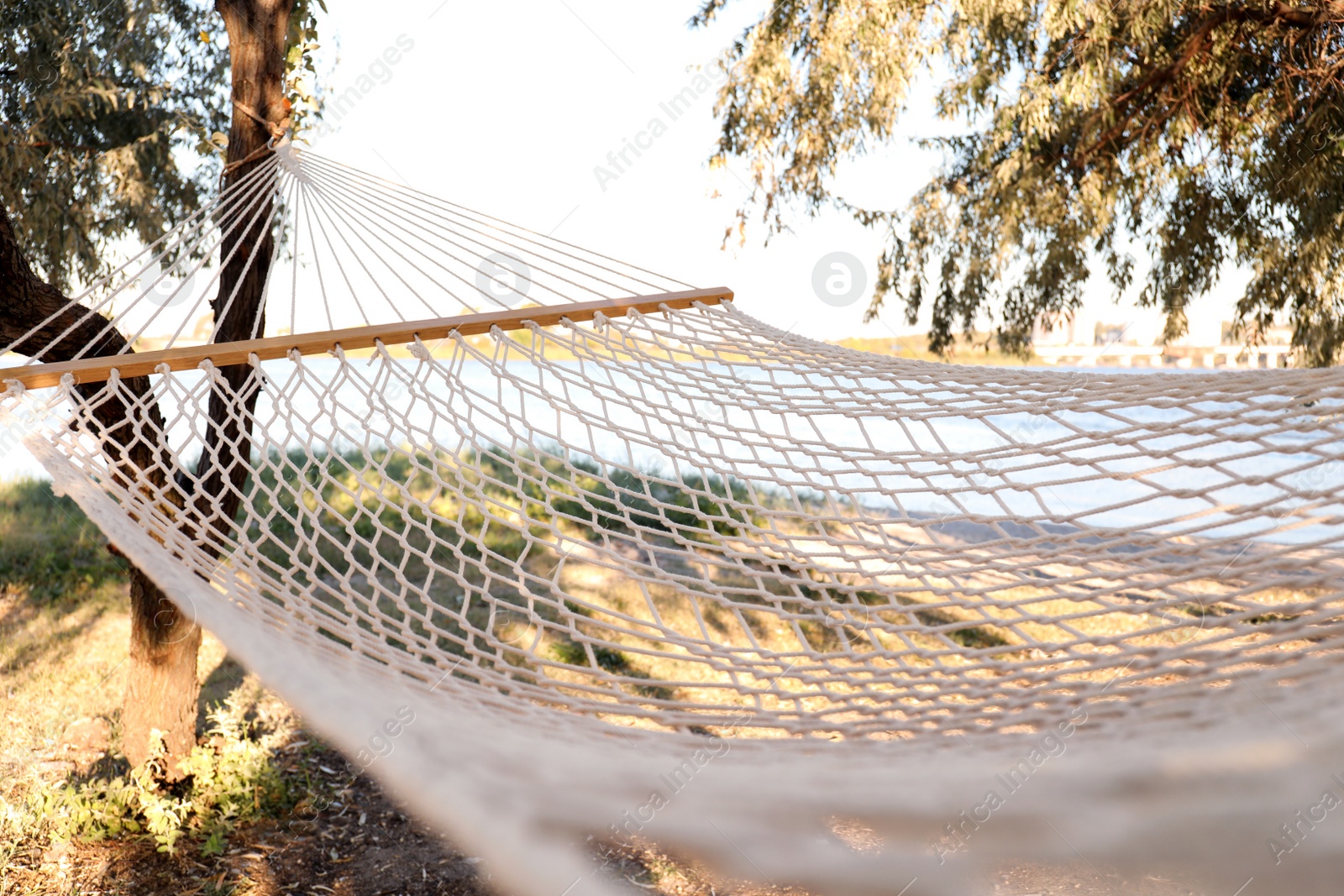Photo of Comfortable hammock on beach, closeup. Summer vacation