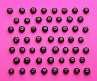 Fresh acai berries on pink background, flat lay