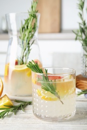 Photo of Refreshing grapefruit cocktail with rosemary on table