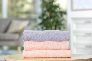 Stack of folded clean soft towels on table indoors