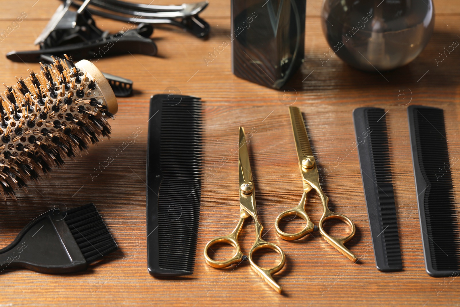 Photo of Hairdresser tools. Different scissors and combs on wooden table