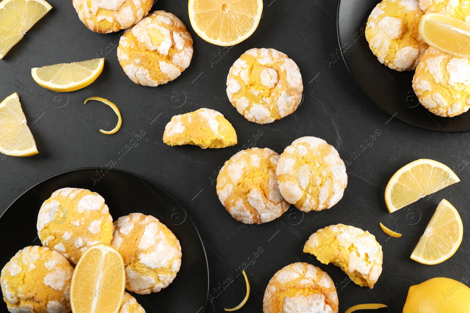 Photo of Flat lay composition with delicious lemon cookies on black table