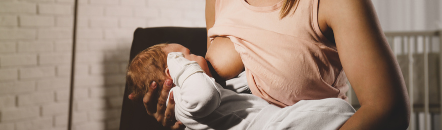 Image of Young woman breast feeding her little baby at home, closeup. Banner design