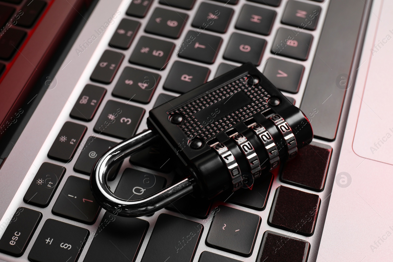 Photo of Cyber security. Metal combination padlock on laptop, closeup