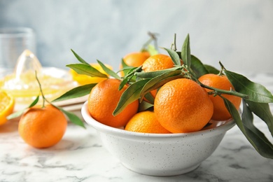 Photo of Bowl with ripe tangerines on table. Citrus fruit