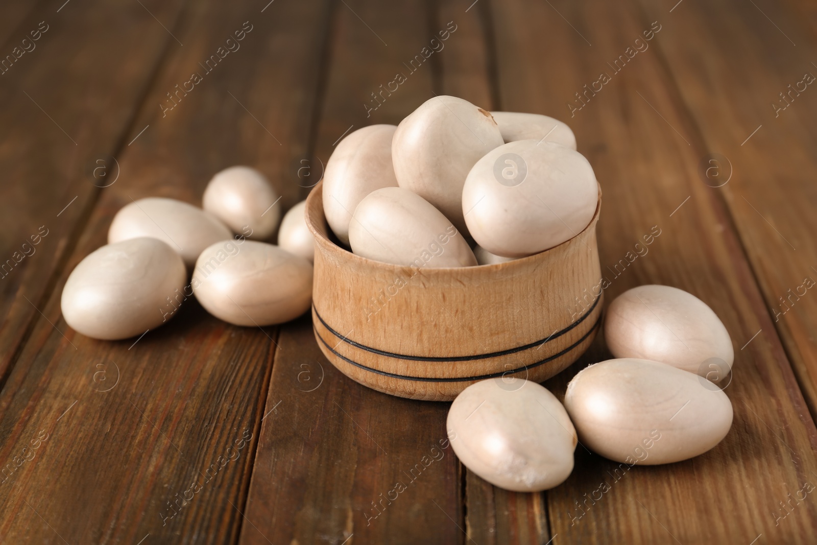 Photo of Raw jackfruit seeds in bowl on wooden table, closeup