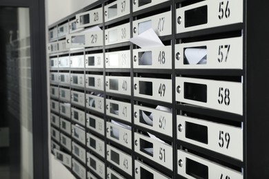 Photo of New mailboxes with keyholes, numbers and receipts near entrance in post office